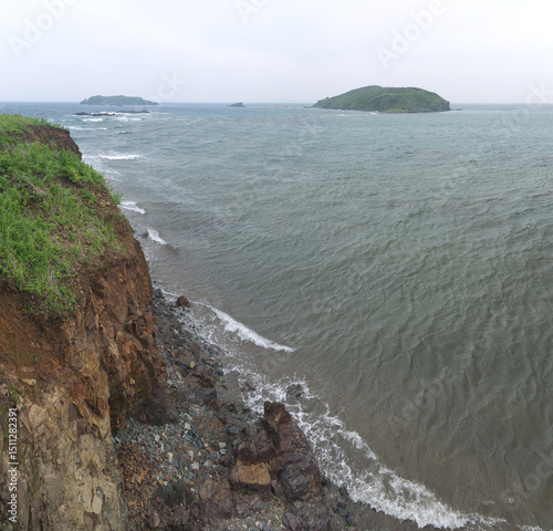 Looking down to the sea and small island from the top of the high cliff