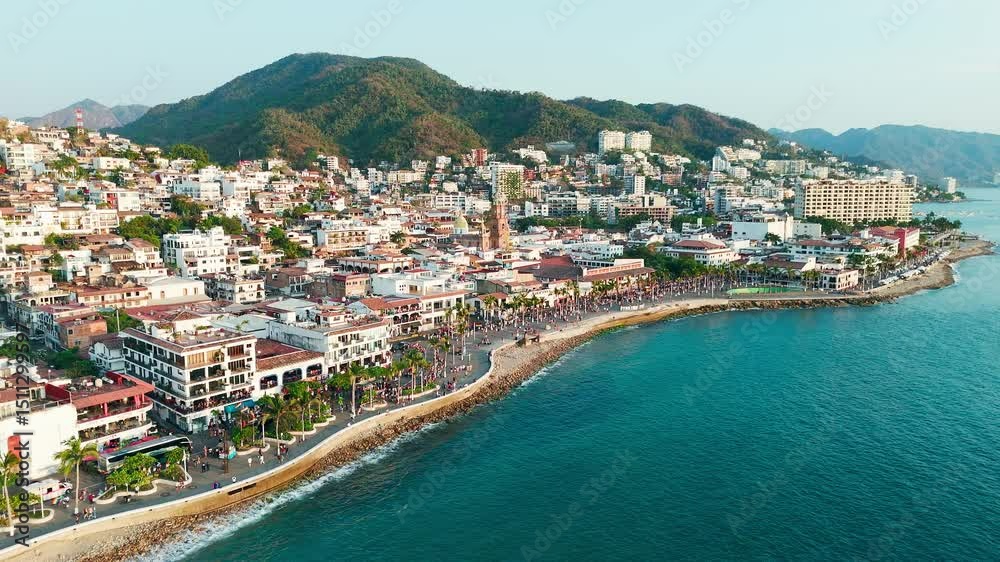 Pride parade passing through downtown puerto vallarta mexico at sunset, church standing out in background Pride parade passing through downtown puerto vallarta mexico at sunset, church standing out in background