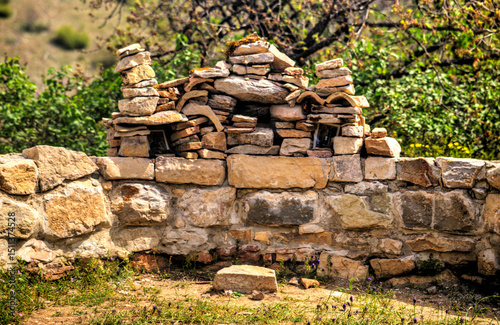 An ancient stone wall with built stone proskinitarium on it