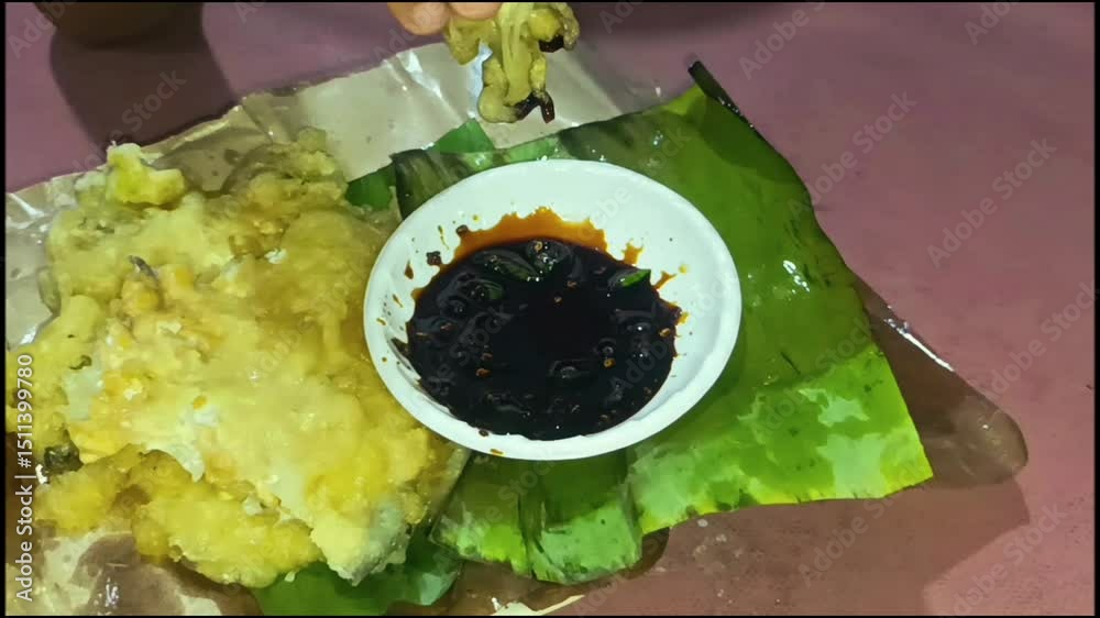 Tempe Mendoan (Indonesian), thinly sliced fried tempeh made from tempeh wrapped in seasoned flour. Served with sweet soy sauce, sliced shallots and green chilies. Traditional Indonesian food.