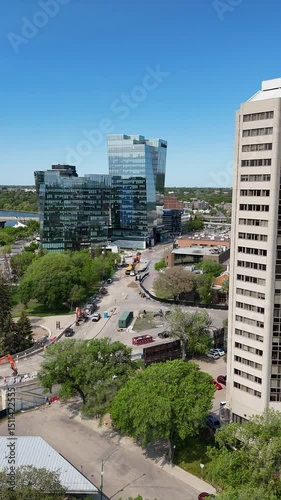 Tall building with a lot of windows and a parking lot below. The building is surrounded by trees and cars