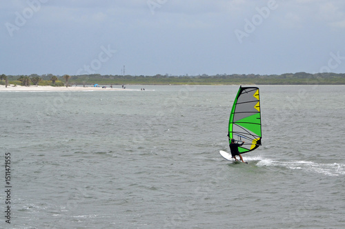 A windsurfer on the ocean, New Smyrna Beach on the horizon in Florida. 