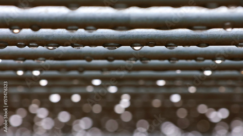 Raindrops on horizontal bars. Selective focus. Abstract background with water drops and bokeh.