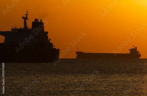 Cargo vessel in the middle of the ocean when it is almost night	