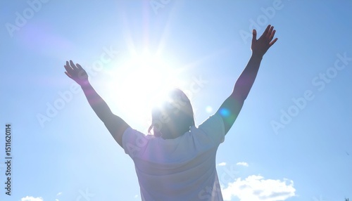 Person with arms raised high towards the sun on a clear day. Image evokes feelings of freedom, joy, and hope.