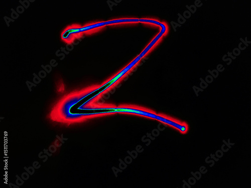 Glowing English letter Z. On a black background with colored neon lines, a letter of the English alphabet is written by hand. The letter glows pink-red, creating a green-blue halo around it.