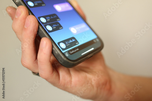 Hand holding smartphone with voice messages open in a chat app. Close-up of screen with audio messages, modern communication, messaging and mobile technology concept.