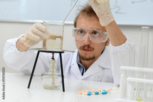 Biologist examines analysis data from a heated chemical flask. High quality photo