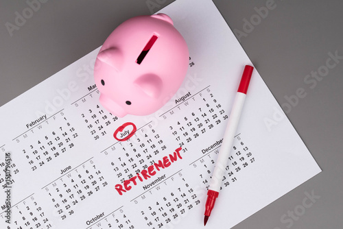 Fototapeta Naklejka Na Ścianę i Meble -  Piggy bank and calendar with the word 'Retirement' written on it, as savings for retirement and planning. Concept of early retirement, the Financial Independence, Retire Early movement (FIRE).