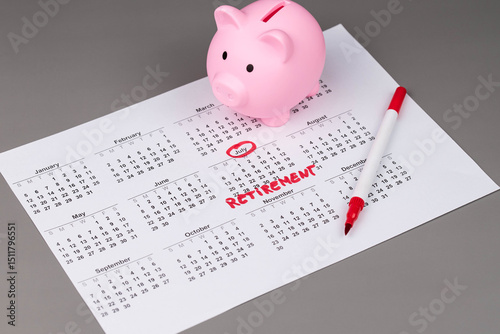 Fototapeta Naklejka Na Ścianę i Meble -  Piggy bank and calendar with the word 'Retirement' written on it, as savings for retirement and planning. Concept of early retirement, the Financial Independence, Retire Early movement (FIRE).