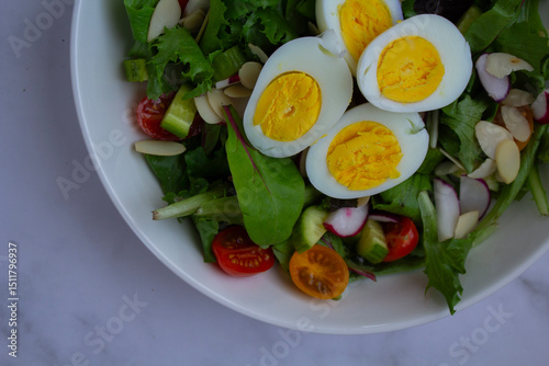 Fresh and vibrant homemade salad topped with sliced eggs and a light vinaigrette photo