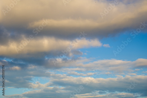 A colorful sunset sky with vibrant hues of purple, pink, and yellow blending seamlessly into each other. Abstract clouds add texture and depth to the scene, enhancing the dramatic effect of the colors