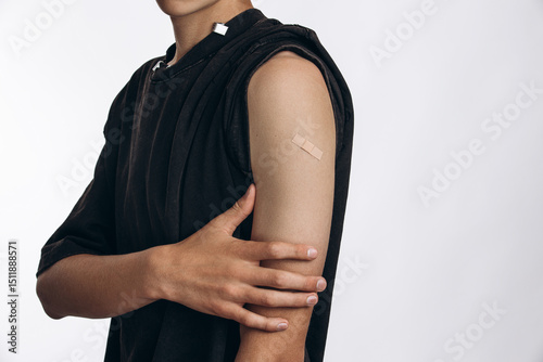 One Small Patch, One Big Step for Health
Teenager Showing Arm with Band-Aid After Vaccination in Studio...