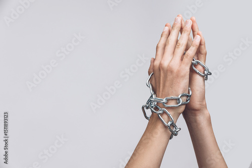 Hands Tied with Metal Chain as Symbol of Captivity and Oppression on Neutral Background