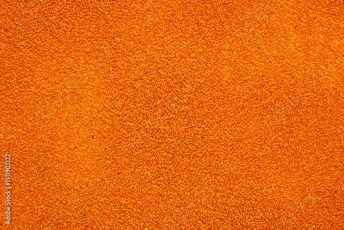 A detailed closeup image showing a vibrant pile of orange glitter
