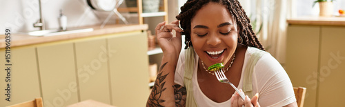 Slika na platnu Joyful moments of a young woman enjoying a fresh salad at home during lunch