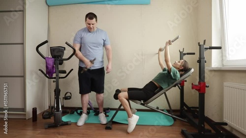 Man and Woman Working Out with Weights on Home Gym Bench Near Window