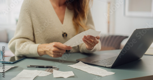 Fotografi White Woman in Cream Cardigan Reviews Receipts at Her Laptop