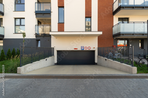 Secure underground parking garage with a closed roller door at a new residential building. This modern infrastructure includes a bicycle rack, showing thoughtful design for residents' vehicles.
