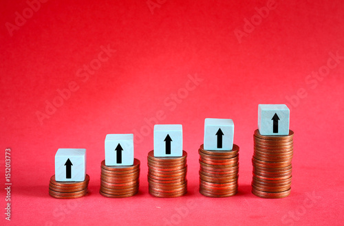 Business concept for financial growth, interest rate increase, inflation, high price, tax and tariffs rise . Arrow up sign on wooden cube blocks above stack of coins, free copy space