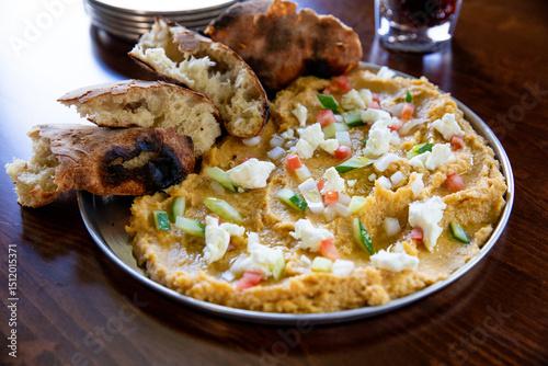Platter of hummus with veggies and crusty bread 