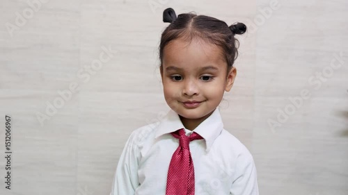 indian kid cute expression getting ready for first day of school shirt and tie at indoor