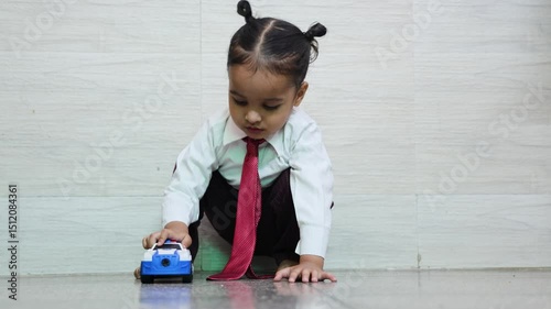 indian kid cute expression while playing with toy car at indoor