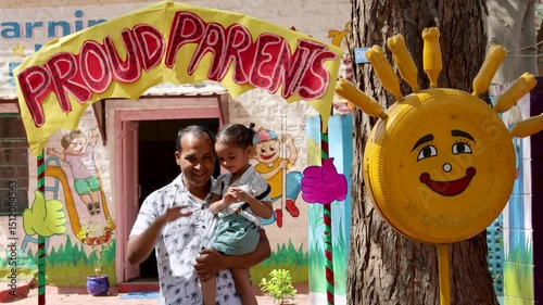 father and son enjoying proud parents photo zone at preschool outdoor