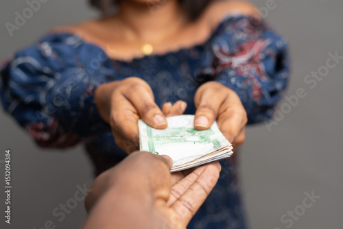 African lady stretching forward some money to give someone