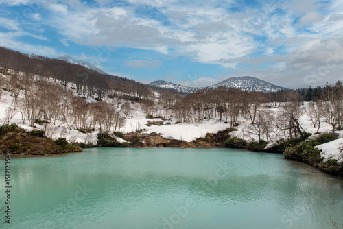 Early spring with still snow on the ground of the Hakkoda Jigoku-numa Pond a crater lake with sulfur pond and natural hot spring (also Hell Lake) along National Route 394 near Aomori, Japan photo
