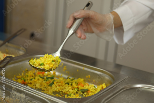 Fototapeta Naklejka Na Ścianę i Meble -  School canteen worker at serving line, closeup. Tasty food