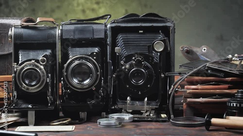 Old cameras in a composition on a wooden background, slowly moving in a horizontal plane.