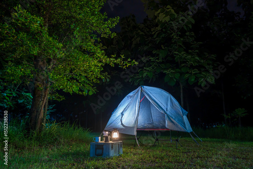 Camping tents at night  in a forest  and outdoor coffee-making facilities on tables