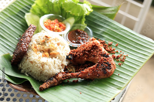 Nasi Liwet Ayam Rempah, Spiced Rice Served with Tempeh and Traditional Fried Chicken photo