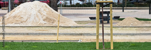 Sand mounds echo beach dreams in urban playground construction, symbolizing renewal and celebration of Earth Day's sustainable design
