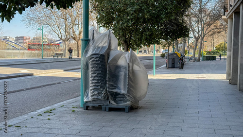Veiled urban sculptures, enigmatic street silence during La Tomatina's off-season, a playful mystery wrapped in translucent stillness