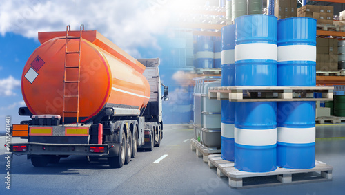 Fuel tanker truck transporting flammable liquid passes by pallets of chemical barrels at industrial warehouse. Activity: Chemical transport, hazardous materials logistics.