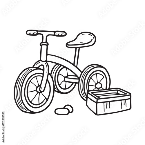 A tricycle standing near an overturned toy box