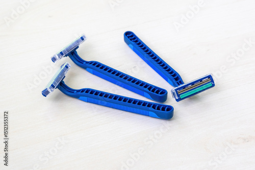 Three new blue razors with sharp blades isolated on white.