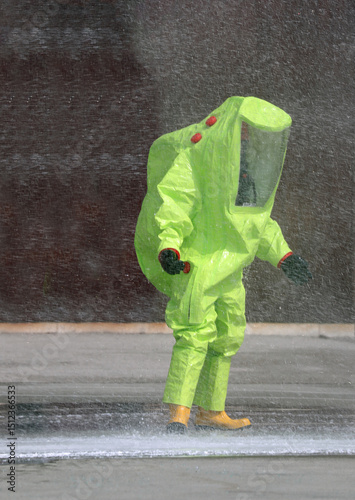 person with  protective suit with contamination by chemical and bacteriological agents and water sprays to keep   environment moist