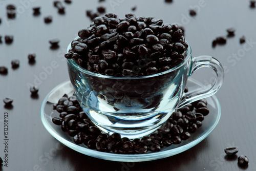 Clear cup brimming with fresh coffee beans photo