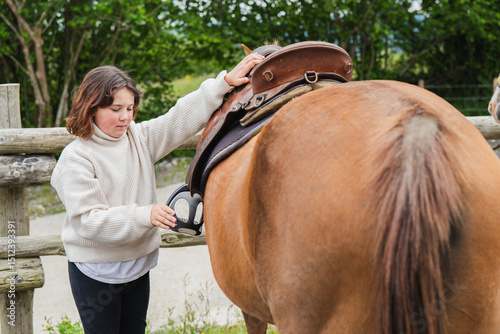 Girl grooming a horse on a farm day