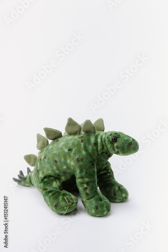 dinosaur stuffed animal sitting on a white background