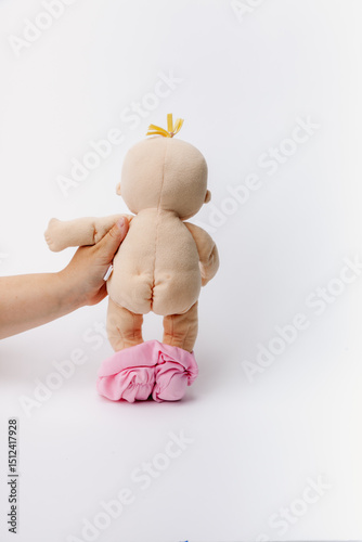 Baby stuffed doll flashing back side on a white background