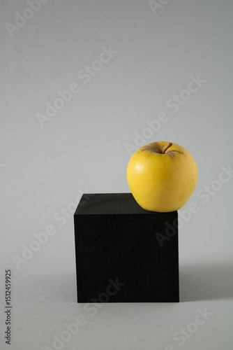 Yellow apple on a black box