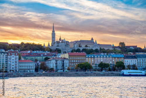 Captivating Sunset Photo of Matthias Church and Fisherman's Bastion with the Danube River in the Foreground, Showcasing Historic Architecture in the Heart of Budapest, Hungary