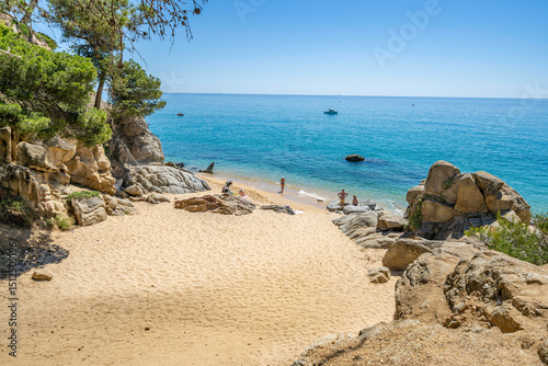 Tourists relaxing on sandy beach at cala estreta, palamos, costa brava, spain