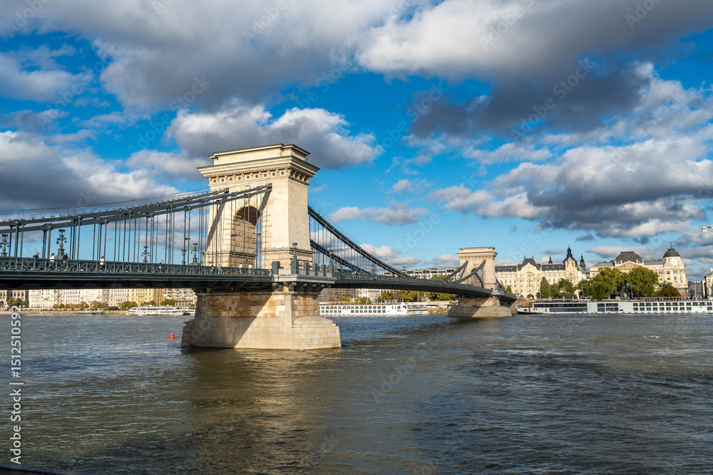 Obraz premium Scenic Daytime View of the Chain Bridge in Budapest with a Boat Gently Floating on the Danube River
