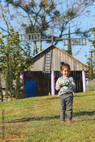 Pequena fotógrafa explorando uma linda fazenda com sua câmera