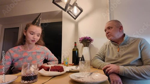 Three generations of a happy family — grandmother, grandfather, mother, and daughter — celebrating the little girl’s birthday together at home, enjoying a warm and joyful moment.